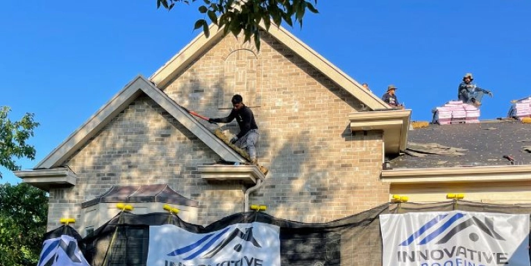 Roofer repairing damaged shingles on a Central Kentucky home